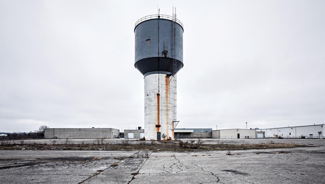flux pro 2.0 A utilitarian concrete water tower standing alone against an overcast sky functi 3